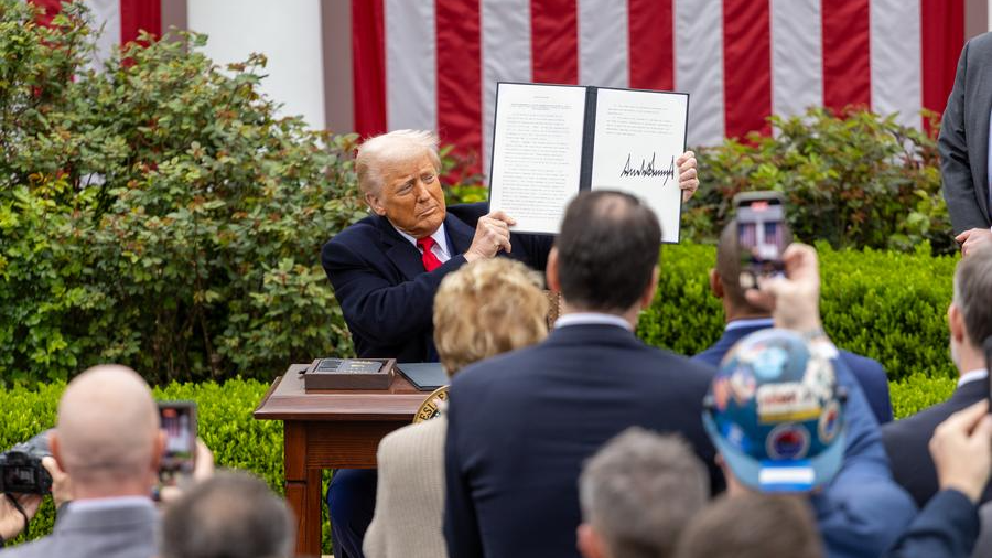 U.S. President Donald Trump shows an executive order on 